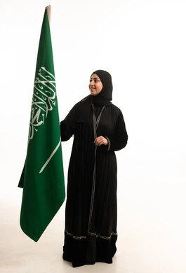 Saudi Woman in Abaya Holding Saudi Arabia Flag