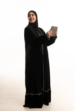 امرأة سعودية بالعباءة تستخدم جهاز لوحي رقمي