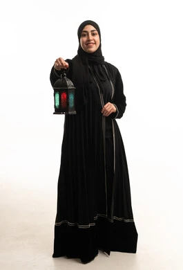 امرأة سعودية بالعباءة السوداء تحمل فانوس رمضان