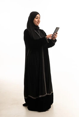 امرأة سعودية بالعباءة السوداء تستخدم جهاز لوحي في الاستوديو