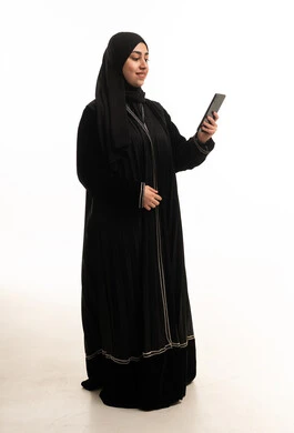 امرأة سعودية بالعباءة السوداء تستخدم الهاتف المحمول
