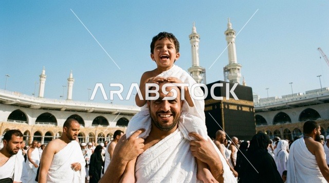 رجل وطفل بملابس الإحرام أمام الكعبة في مكة