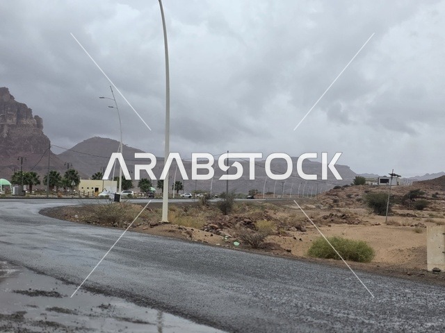 طريق مبلل في جبال تبوك السعودية تحت سماء غائمة