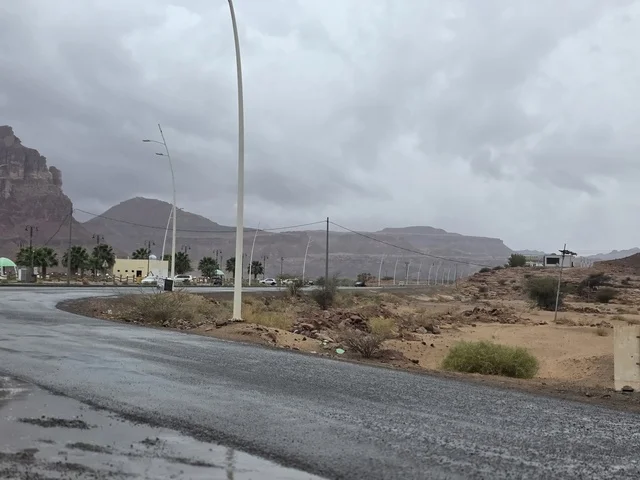 طريق مبلل في جبال تبوك السعودية تحت سماء غائمة