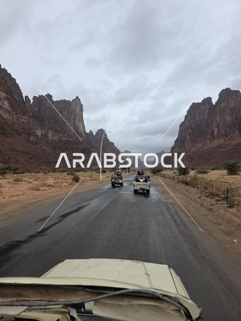 سيارات على طريق مبلل عبر جبال تبوك السعودية