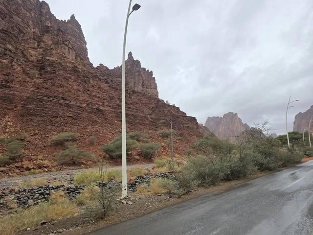 Wet Asphalt Road through Red Tabuk Mountains Saudi Arabia