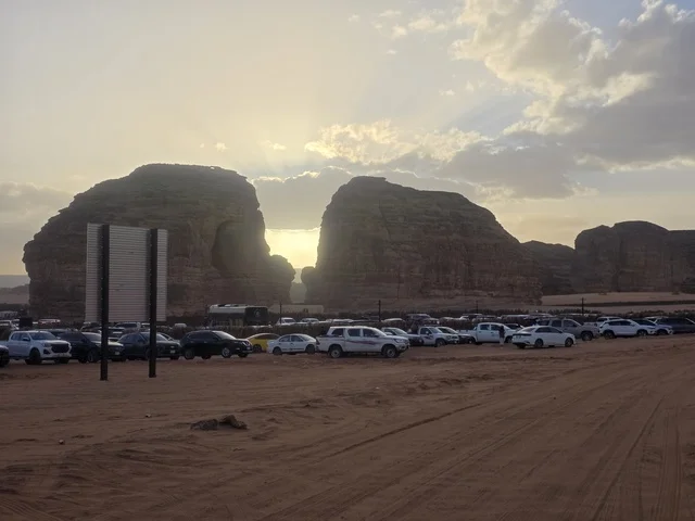 جبال العلا في السعودية عند الغروب وموقف السيارات