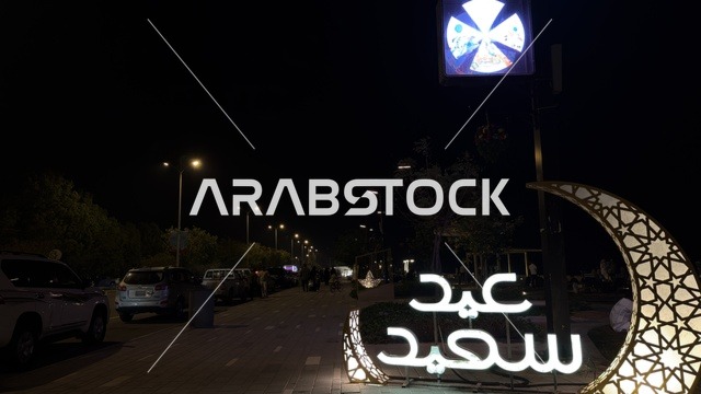 لوحة عيد سعيد المضيئة وزينة الهلال في مدينة الدمام ليلاً