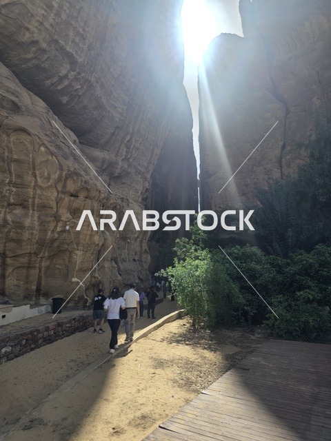 سياح في أخدود العلا الصخري مع أشعة الشمس