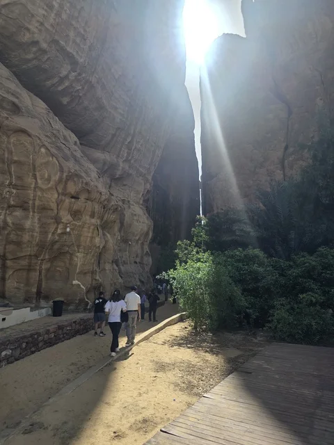 سياح في أخدود العلا الصخري مع أشعة الشمس
