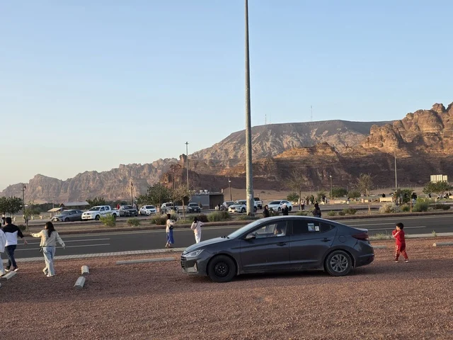 سياح وسيارات في منطقة جبلية بمدينة العلا السعودية