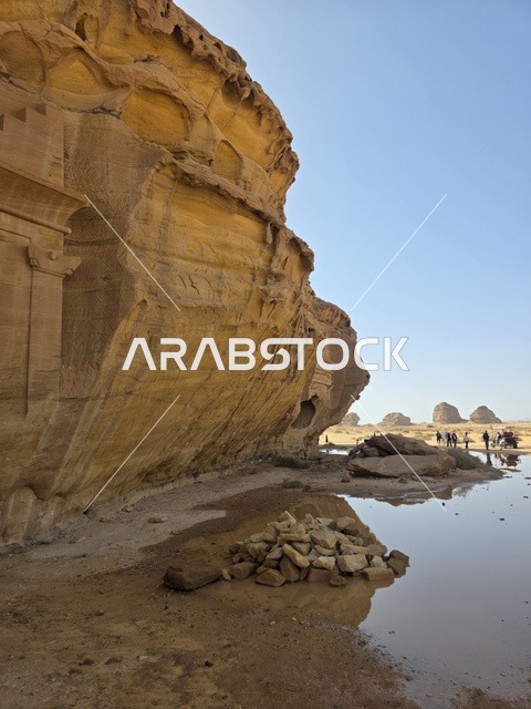 Natural sandy rock formations in the Al-Ula desert in the Kingdom of Saudi Arabia. Daylight highlights the geological terrain and sandy land under a clear sky, tourism in Al-Ula.