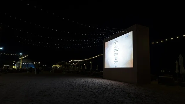 شاشة سينما خارجية في بنانا بيتش الجبيل ليلاً