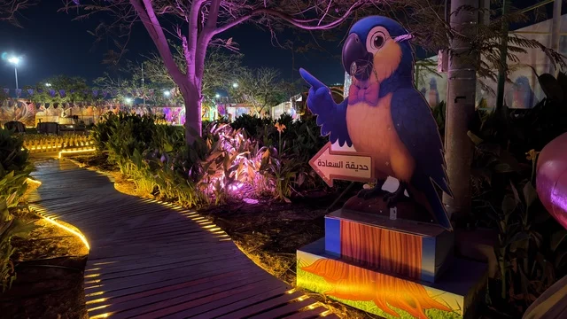 حديقة العجائب في الجبيل ليلاً مع تمثال الببغاء