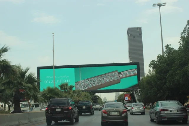 Traffic Passing Digital Billboard on Riyadh City Road