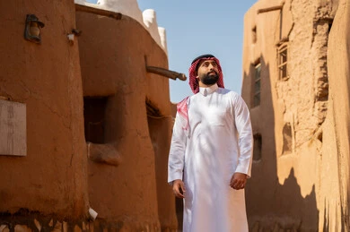 رجل سعودي بالزي التقليدي في موقع تراثي