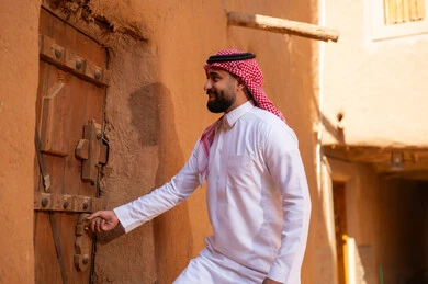 رجل سعودي بالزي التقليدي في قرية تراثية قديمة