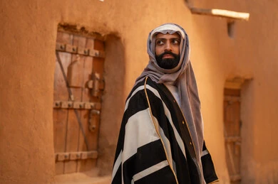رجل سعودي بالبشت التقليدي في قرية تراثية