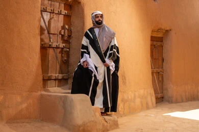 رجل سعودي يرتدي البشت التقليدي في قرية تراثية
