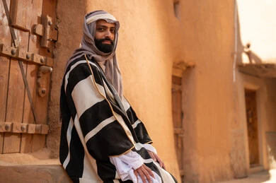 رجل سعودي بالفروة التقليدية في قرية تراثية