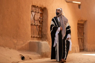 رجل سعودي بالبشت التقليدي في قرية تراثية