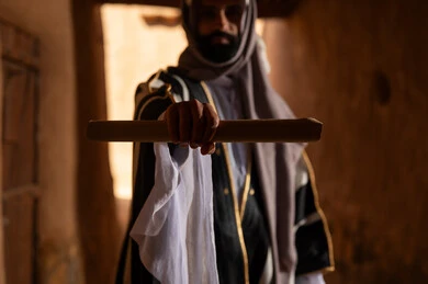 Saudi Man in Traditional Bisht Holding Scroll Old Building