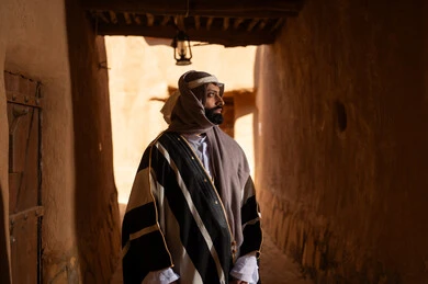 رجل سعودي بالزي التقليدي في حي تراثي قديم