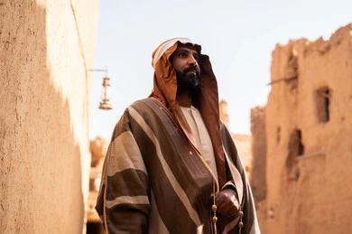 رجل سعودي بالبشت التقليدي في قرية تراثية قديمة