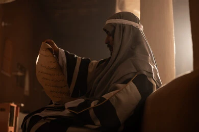 رجل سعودي يقرأ مخطوطة تاريخية قديمة