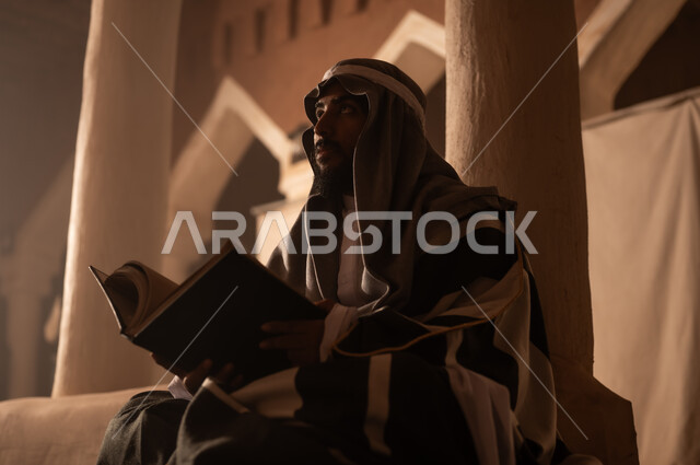Saudi Man Reading Book in Traditional Heritage Site