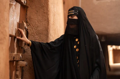 Saudi Woman in Traditional Dress by Heritage Door