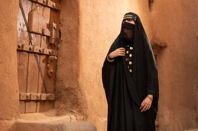 امرأة سعودية باللباس التقليدي في قرية تراثية