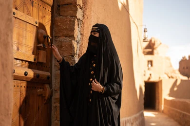 Saudi Woman in Niqab at Traditional Heritage Door