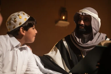 رجل وطفل سعودي يرتديان البشت والثوب في بيئة تراثية