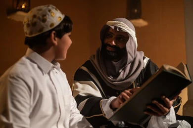 Saudi Man Teaching Boy with Book in Traditional Setting