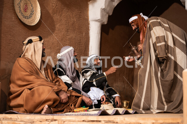 رجال سعوديون باللباس التقليدي التراثي يشربون القهوة