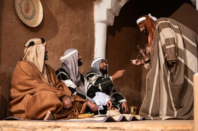 رجال سعوديون باللباس التقليدي التراثي يشربون القهوة