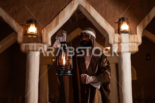 Saudi Man in Heritage Building Holding Kerosene Lantern