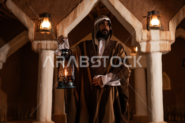 رجل سعودي بالزي التقليدي يحمل فانوساً