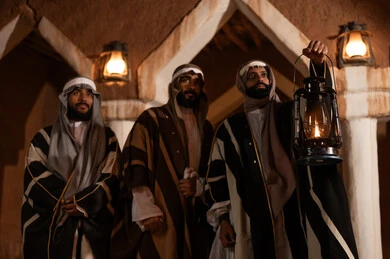 رجال سعوديون بالزي التقليدي والبشت الشتوي مع فانوس