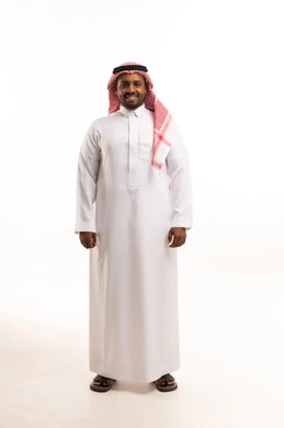 رجل سعودي بالثوب والشماغ التقليدي يقف في الاستوديو