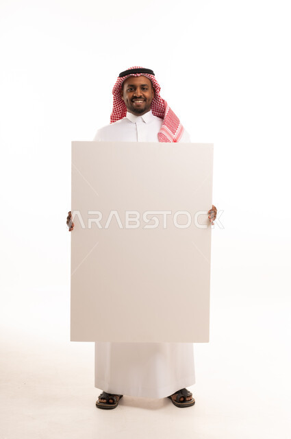 رجل سعودي يحمل لوحة بيضاء فارغة بخلفية بيضاء