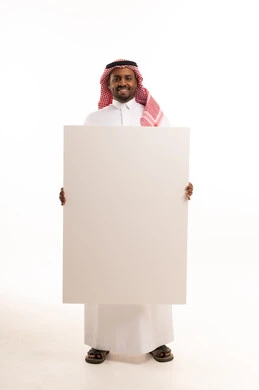 رجل سعودي يحمل لوحة بيضاء فارغة بخلفية بيضاء