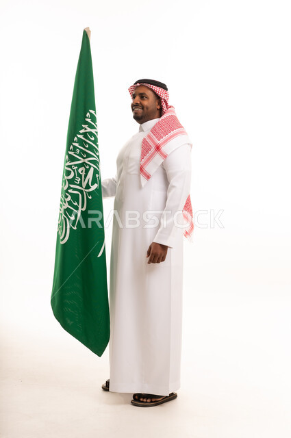 رجل سعودي بالزي التقليدي مع العلم الوطني خلفية بيضاء