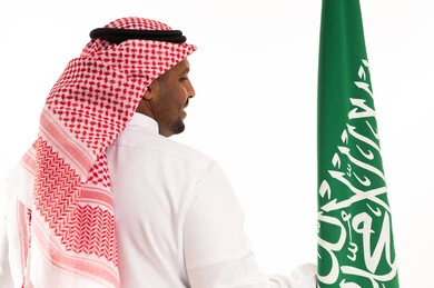 Saudi Man with National Flag in Traditional Attire