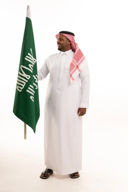 Saudi Man Holding National Flag in Traditional Dress
