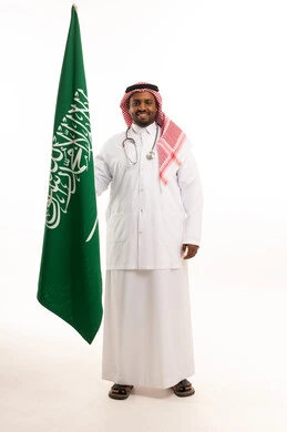 طبيب سعودي يحمل العلم الوطني في استوديو