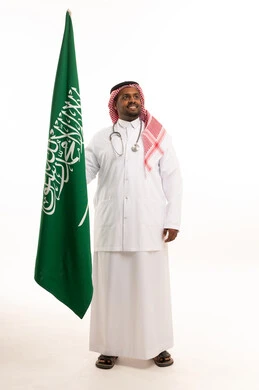 طبيب سعودي يحمل علم المملكة العربية السعودية