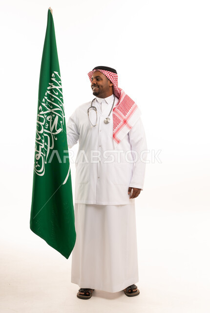 طبيب سعودي يحمل علم السعودية على خلفية بيضاء