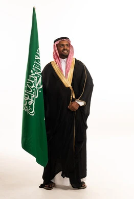 Saudi Man with National Flag in Traditional Bisht